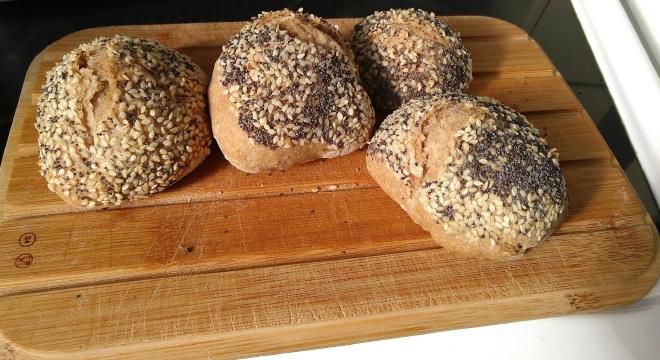 Four bread rolls on a board